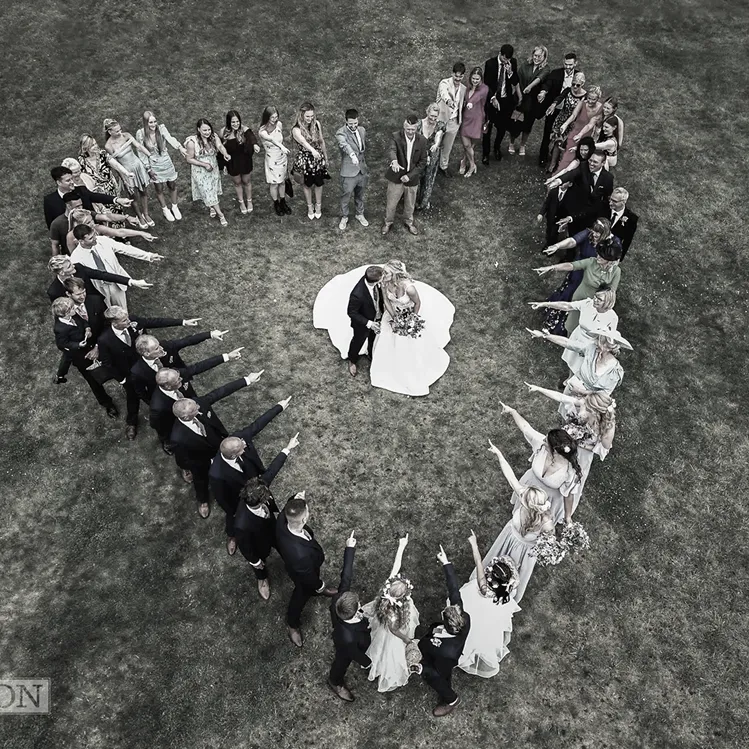 Wedding party arranged in a heart formation, shot from above