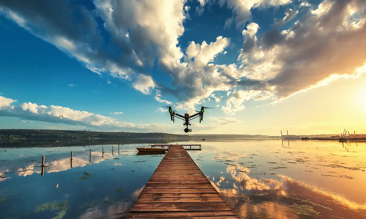 Drone hovering over a pier at golden hour